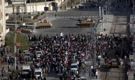 Egyptian army tanks secure the perimeter of the presidential palace while protesters gather chanting