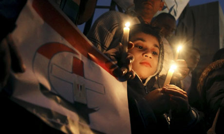 An Egyptian boy  in Cairo, Egypt, Friday, Jan. 7, 2011, during a candlelight vigil in mourning for t