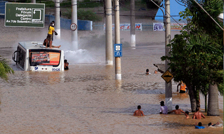  People play in a flooded street (Photo: Reuters)