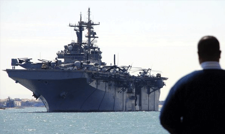 A man looks on as U.S. amphibious assault ship USS Kearsarge sails through the Suez canal in Ismaili