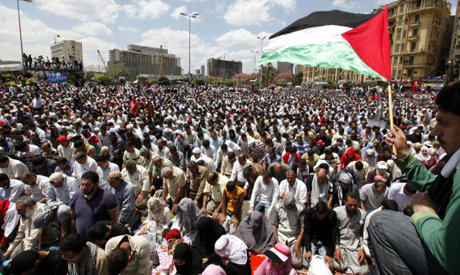A boy holds a Palestinian flag during Friday prayers at Tahrir Square in Cairo