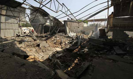 Palestinians survey the damage to what they say is an animal food shed after an overnight Israeli ai