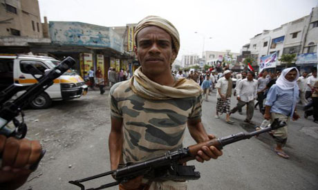 An armed opposition follower poses as he escorts anti-government protesters during a demonstration i