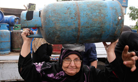 A woman carries a gas cylinder