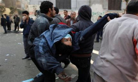 Egyptian protesters take injured protester to a field hospital during clashes with CSF (Photo: AP)