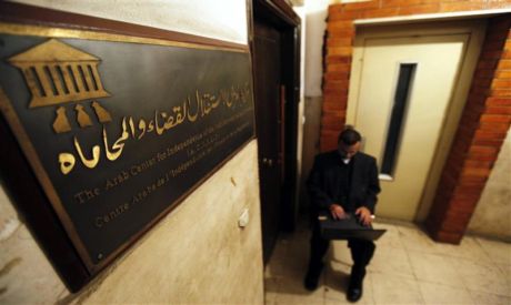 An Egyptian human rights worker uses a laptop computer at the entrance of the office of an non-gover