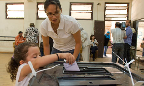 A child learns how to cast her ballot (Bassam Elzoghbi)