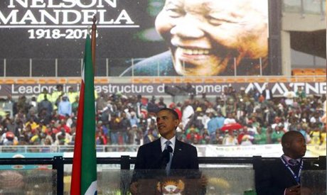 U.S. President Barack Obama gives a speech as a man passing himself off as a sign language interpret