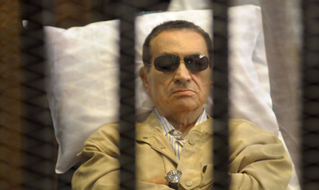 Mubarak sits inside a cage