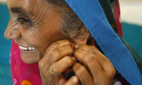 Farmer Bachiben Kolipatle, 63, wears a silver ring before trying a gold earring inside a jewellery s