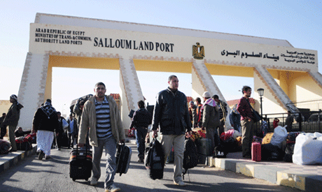 File photo: Egyptians cross from Libya to Egypt through the Salloum land port gate (AP)
