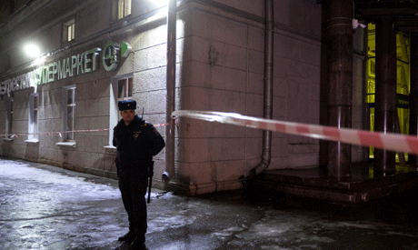 A police officer cordons off the site of a blast in a supermarket in Saint Petersburg on December 27