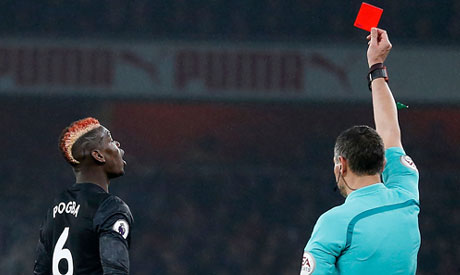 Referee Andre Marriner shows a red card to Manchester United