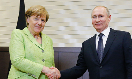 Russian President Vladimir Putin shakes hands with German Chancellor Angela Merkel  (AFP)