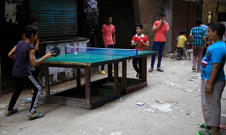 Egyptian boys play table tennis in an alleyway at the Boulaq El Dakrour district of Giza, near Cairo