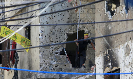 A Palestinian Fatah fighter walks through a hole in a wall inside the Ain el-Hilweh refugee camp nea