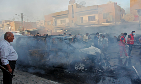 People gather at the site of an explosion in the northeastern Syrian Kurdish city of Qamishli