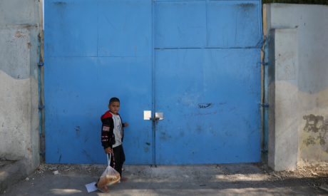 A boy walks in front of a closed United Nations-run school