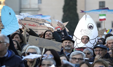 A demonstrator shows a sardine-shaped banner
