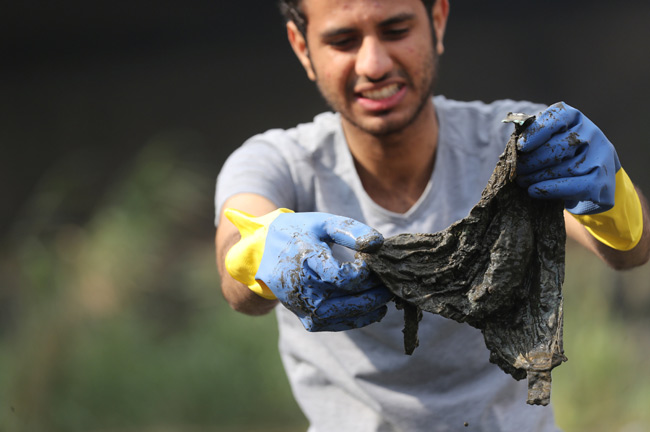 A volunteer collects waste and plastic as part of a campaign to clean up the Nile River sponsored by