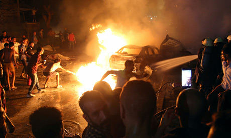 People extinguish a fire from a blast outside the National Cancer Institute, Cairo, Egypt August 4, 