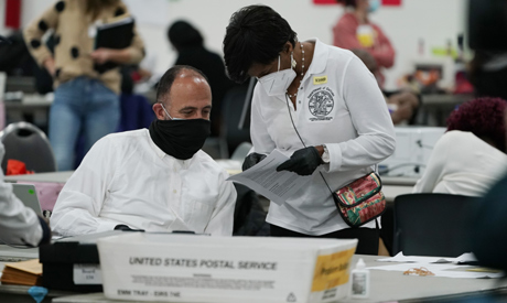 A worker checks with an election supervisor at the central counting board, Wednesday, Nov. 4, 2020, 