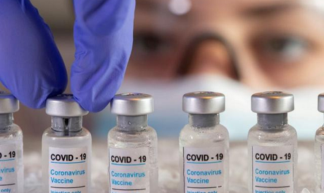 File photo: A woman holding vials labelled "coronavirus vaccine" (Reuters)	