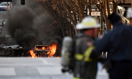 A vehicle burns near the site of an explosion in the area of Second and Commerce in Nashville, Tenne