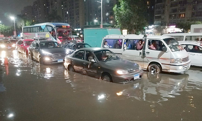 File Photo: Motorists drive on a flooded street following rainfall in Cairo on Tuesday. (AFP)