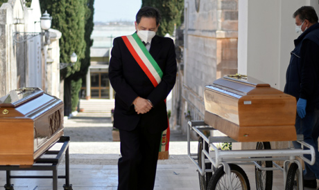 Mayor Luca Convertini stands amid two coffins to mourn victims of coronavirus disease (COVID-19) dur