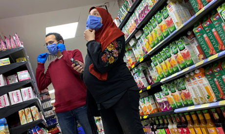 A family with protective masks is seen at a market before the start of night-time curfew to contain 