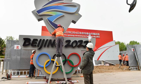 Workers install a Beijing 2022 emblem for a countdown clock to mark the number of days till the open