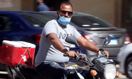 File photo: A man wearing a protective face mask rides a motorbike in Cairo, Egypt (photo: Reuters)