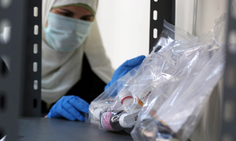 A medical worker wearing a protective face mask and gloves takes the free medicines provided by the 