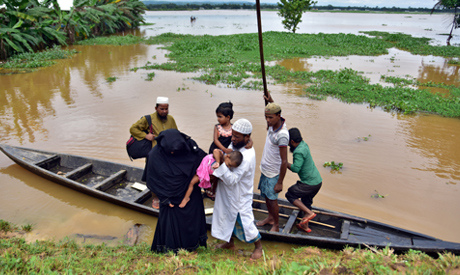 FILE PHOTO: Flood-affected villagers disembark a boat after they reached a safer place at Kachua vil
