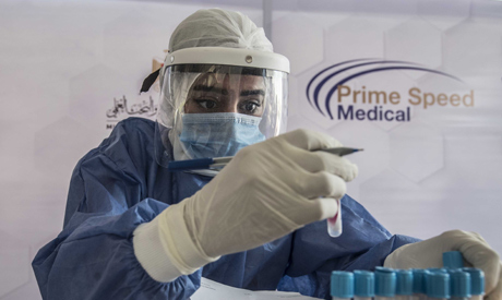An Egyptian health worker checks samples at a drive-through coronavirus-testing center at the Ain Sh