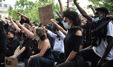 People raise their fists during a rally as part of the ‘Black Lives Matter’ worldwide protests again
