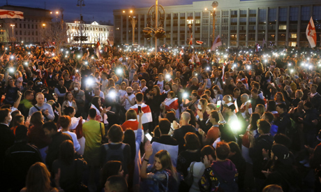 Belarusian opposition supporters light their smartphones as they gather at Independence Square with 