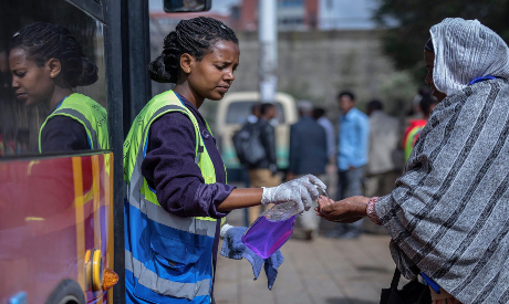 Volunteer provides hand sanitizer to a woman in Addis Ababa