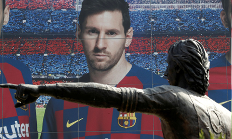 A statue of Johan Cruyff is seen infront of an image of Lionel Messi outside the Camp Nou. REUTERS
