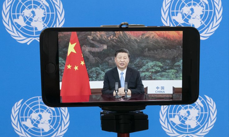 Chinese President Xi Jinping is seen on a video screen remotely addressing the 75th session of the U