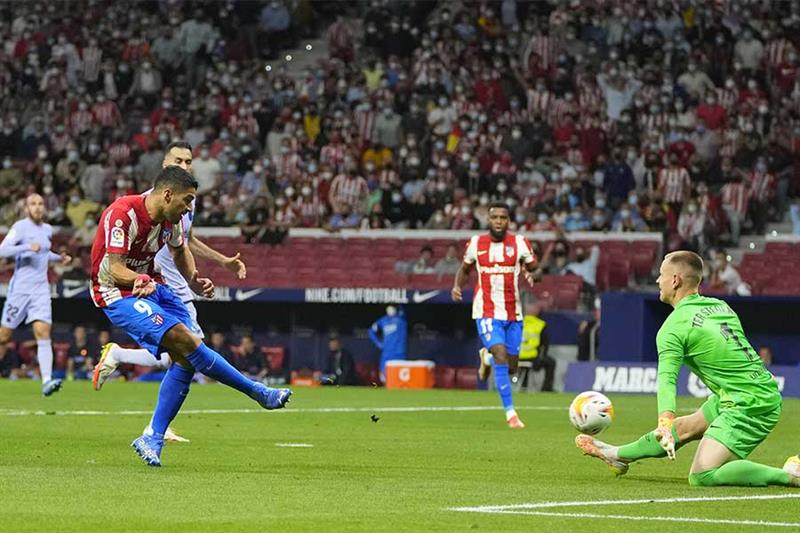 Atletico Madrid s Luis Suarez, left, scores his side s second goal during the La Liga soccer match b