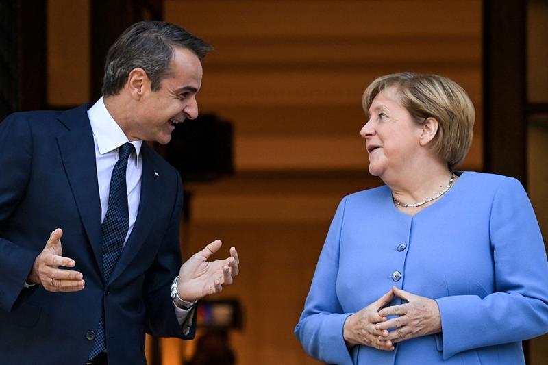 Greek Prime Minister Kyriakos Mitsotakis (L) greets German Chancellor Angela Merkel