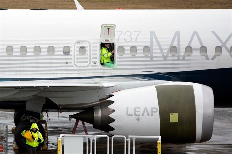 (FILES) In this file photo taken on March 12, 2019, workers are pictured next to a Boeing 737 MAX 9 
