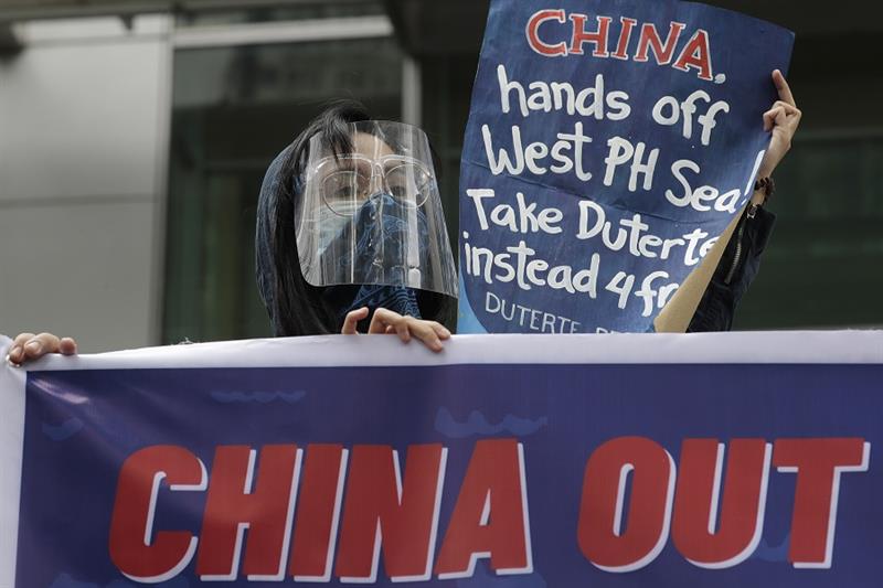 Protesters hold slogans during a rally outside the Chinese consulate in Manila, Philippines