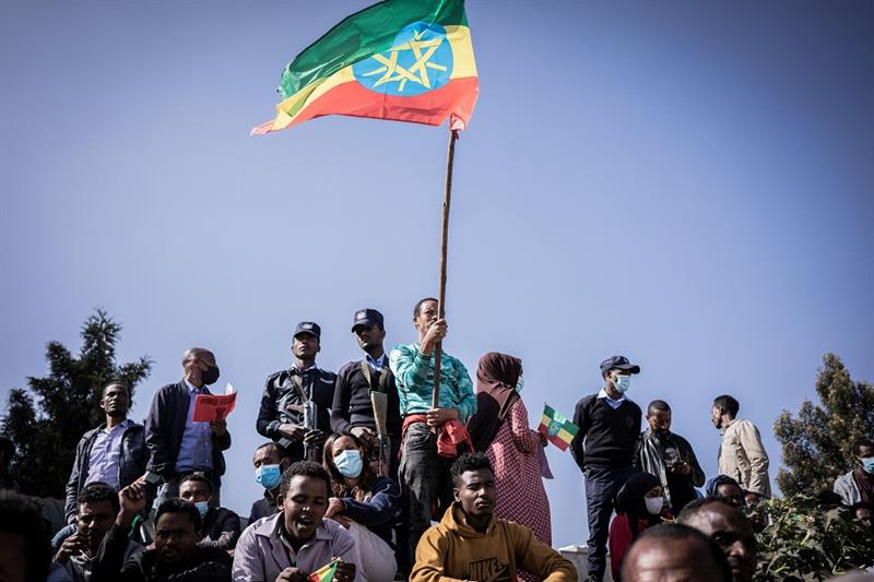 A man holds the Ethiopian national flag as new military recruits who are joining the Ethiopian Natio