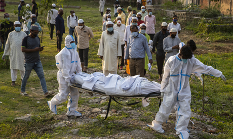 Municipal workers prepare to bury the body of a person who died of COVID-19 in Gauhati, India, Sunda