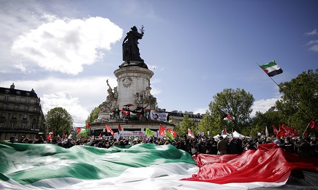 Protesters hold a giant Palestinian flag in Paris, Saturday, May 22, 2021, as they take part in a ra