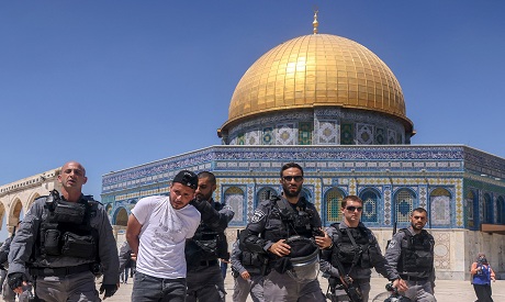 Israeli occupation forces detain a Palestinian man in Al-Aqsa mosque. AFP 