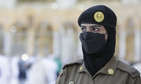 Saudi police woman, Samar, who is recently deployed to the service, stands alert in front of the Kaa